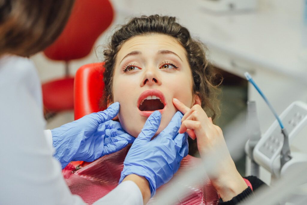 The girl is at the reception of a dentist. Happy client at the dentist smiles. Tooth whitening. Dental clinic. Dental treatment in a modern clinic. Recovery of healing