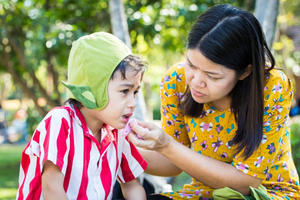 Little boy Bleeding at the mouth and mother help first aid to him